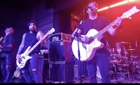 a group of people standing on stage with guitars